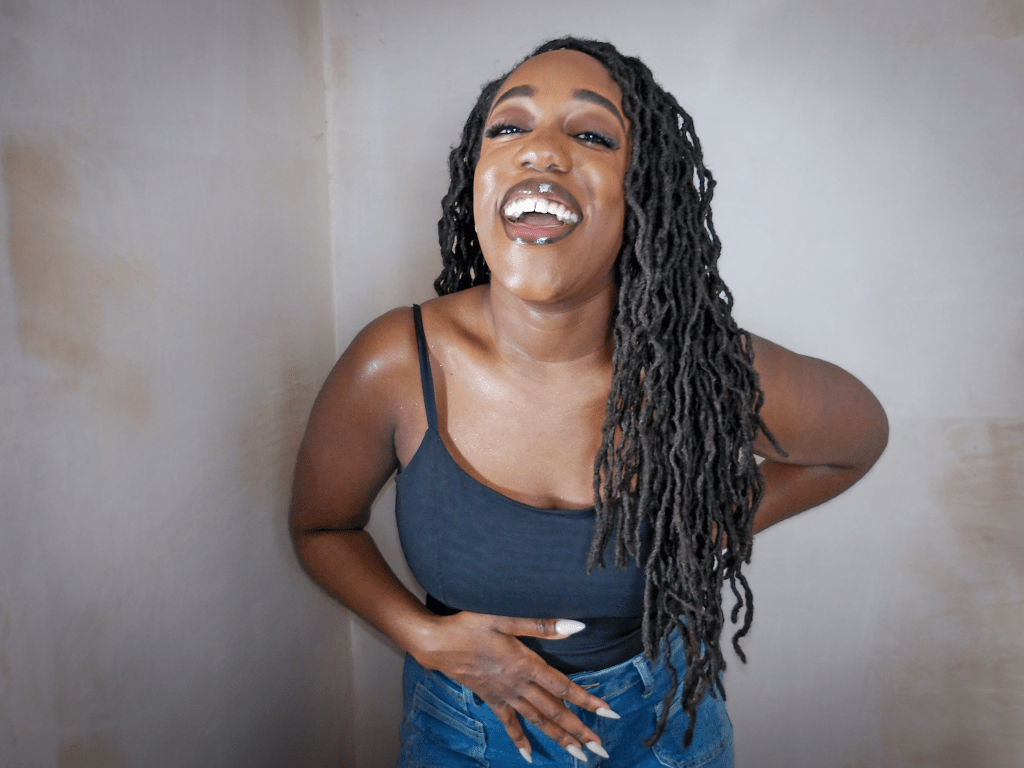 Close up photo of Naomi Sian who is a black lady with long curly locs